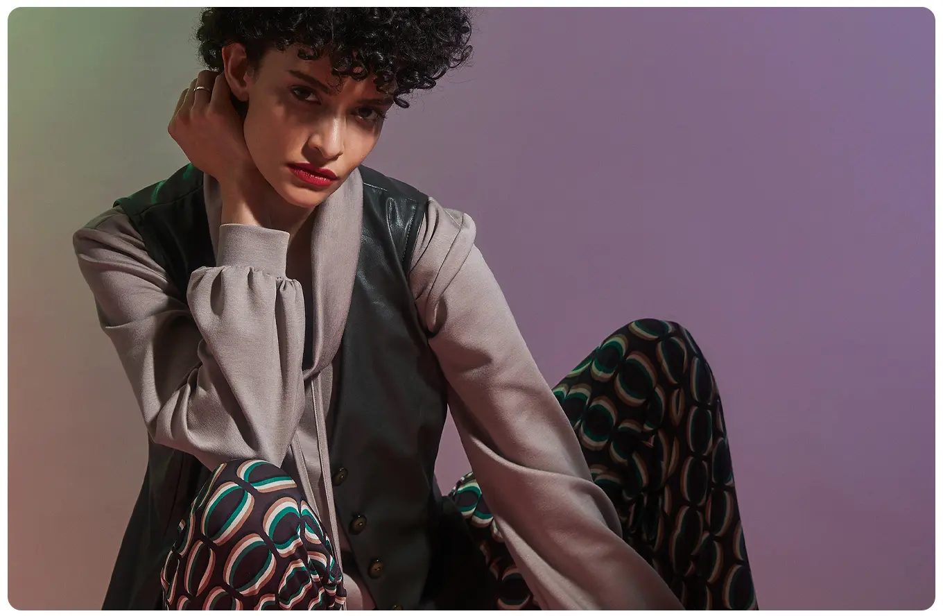 Ana Alcazar Model trägt Rollkragenshirt mit Kunstlederweste und Printhose